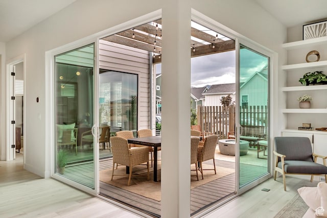 doorway to outside featuring wood finished floors and built in shelves