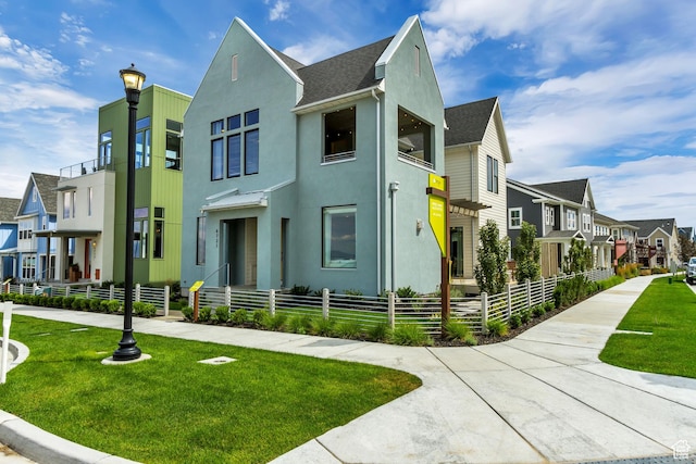 view of front of home featuring a residential view, stucco siding, and a shingled roof