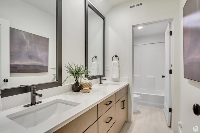 full bath featuring toilet, double vanity, and shower / tub combination