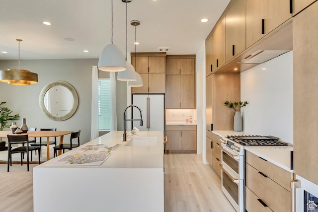 kitchen with white appliances, a sink, light wood-type flooring, recessed lighting, and light countertops