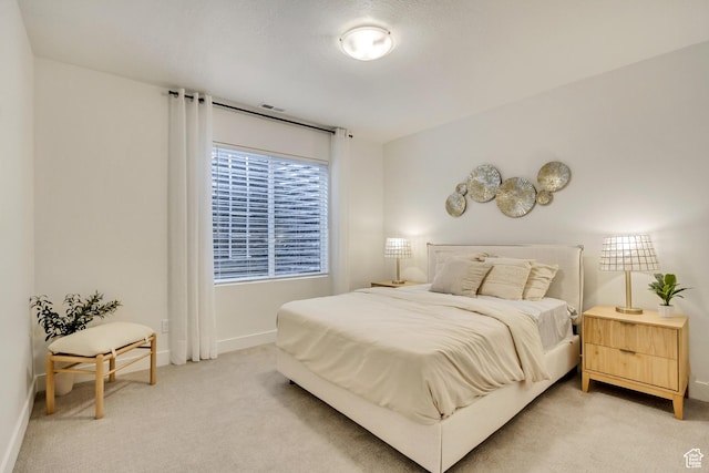 bedroom with light colored carpet and baseboards