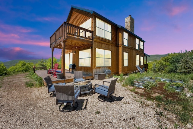 9048 E Acorn Way Unit 984, Heber City, UT 84032 - back of house at dusk featuring a chimney, an outdoor fire pit, a vegetable garden, and a deck