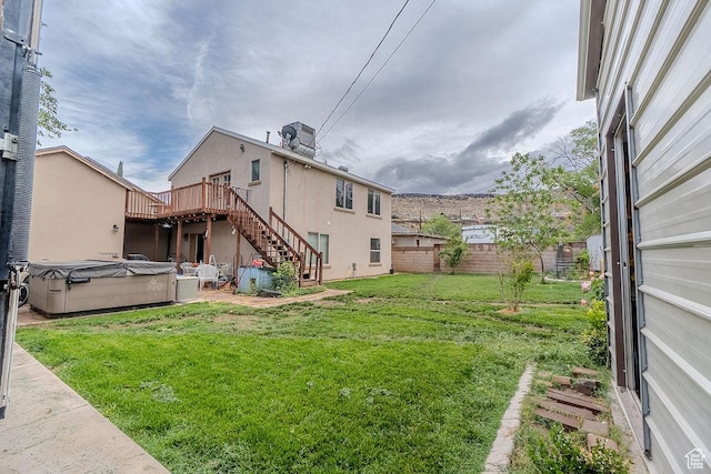 view of yard with a hot tub, stairway, and a deck