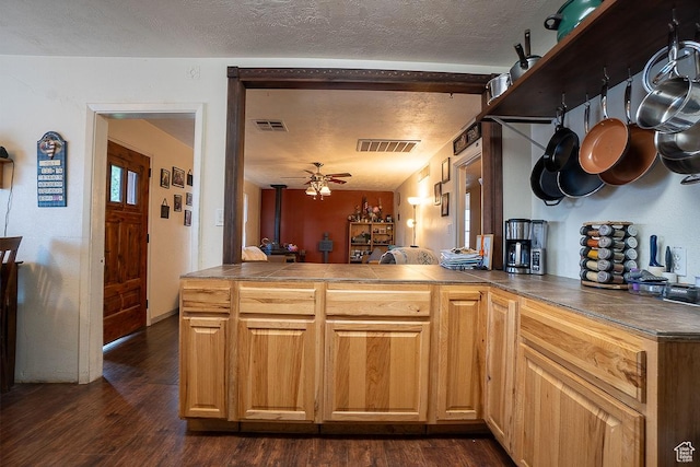 kitchen with ceiling fan, tile countertops, dark wood finished floors, a textured ceiling, and a peninsula