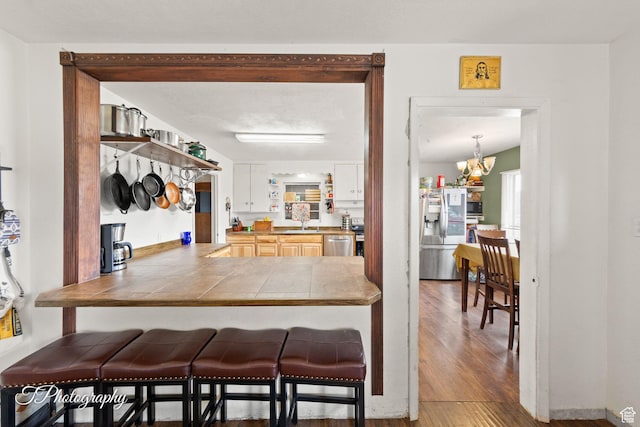 382 W 200 N, St George, UT 84770 - kitchen featuring stainless steel appliances, a kitchen bar, wood finished floors, and tile countertops