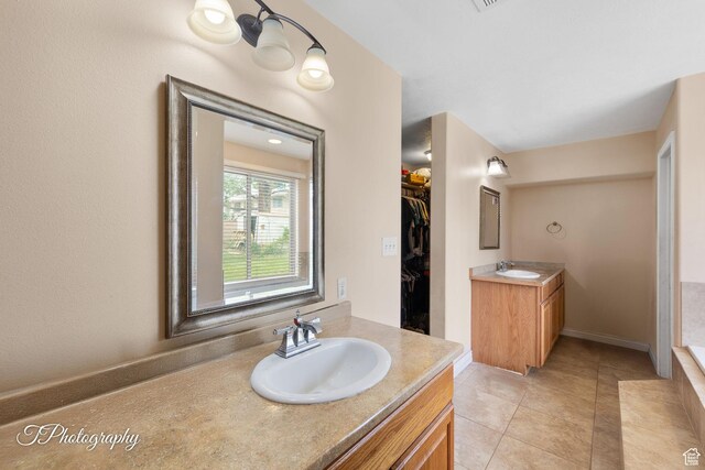 382 W 200 N, St George, UT 84770 - bathroom featuring two vanities, tile patterned floors, a walk in closet, and baseboards
