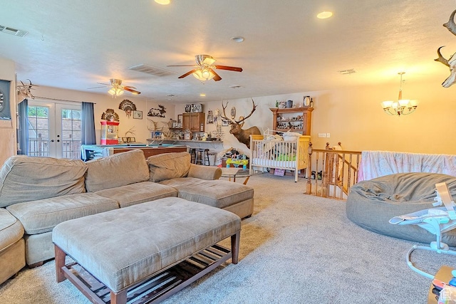 living area featuring light colored carpet, a chandelier, a ceiling fan, recessed lighting, and french doors