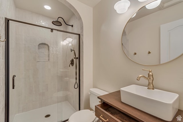 full bathroom with toilet, a stall shower, and vanity