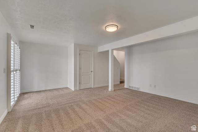 below grade area with light colored carpet and baseboards