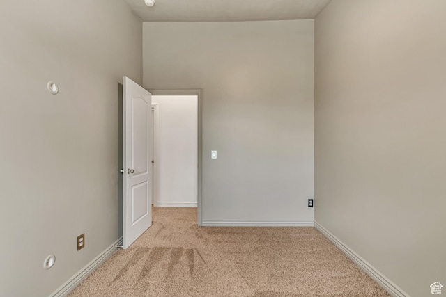 carpeted spare room featuring baseboards