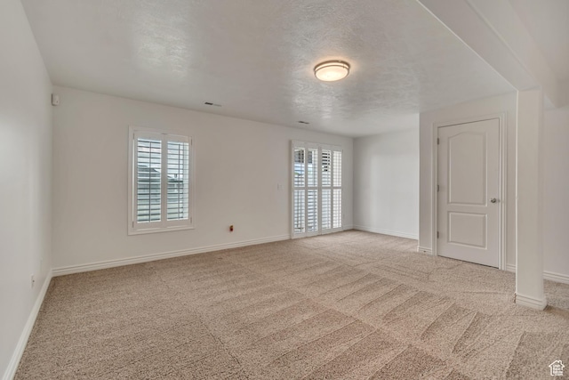 unfurnished room with healthy amount of natural light, carpet flooring, and baseboards