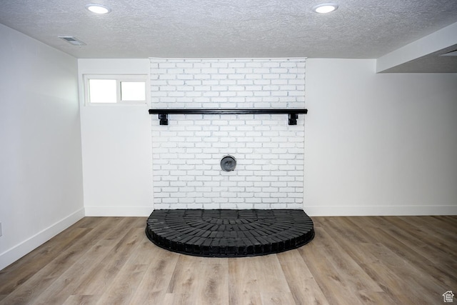 detailed view of a textured ceiling, wood finished floors, baseboards, and recessed lighting