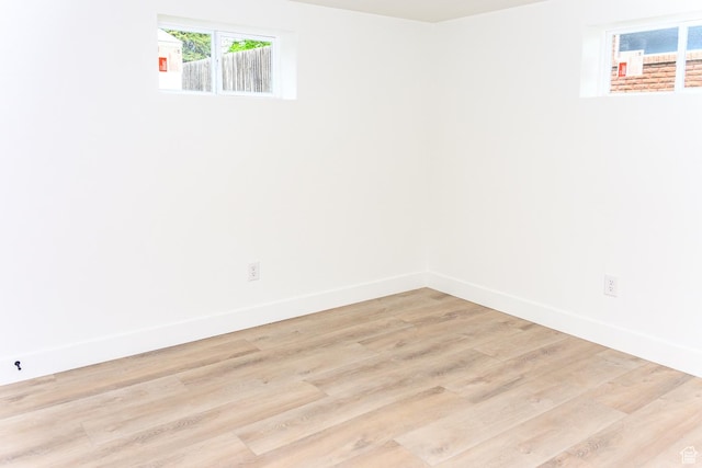 empty room with baseboards and light wood finished floors