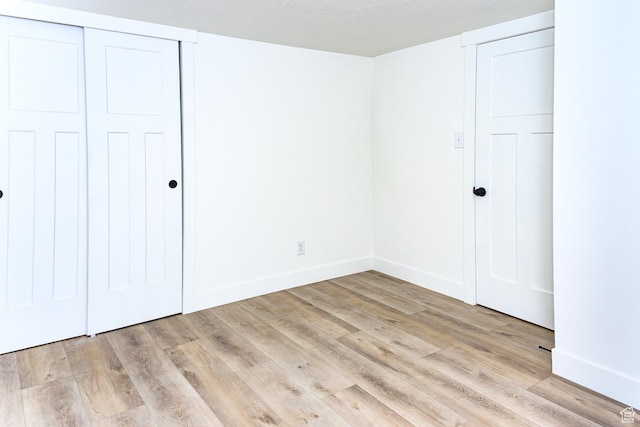 unfurnished bedroom featuring light wood-type flooring and baseboards