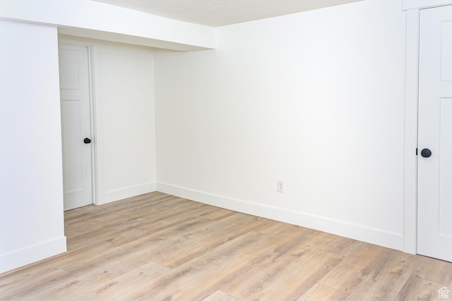 spare room with light wood finished floors and baseboards