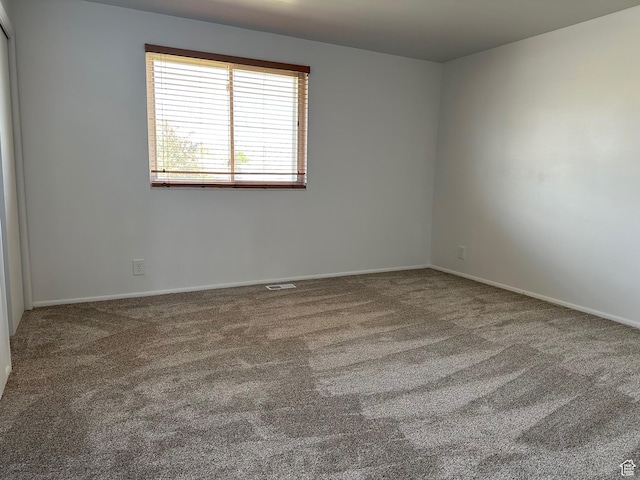 carpeted spare room with baseboards