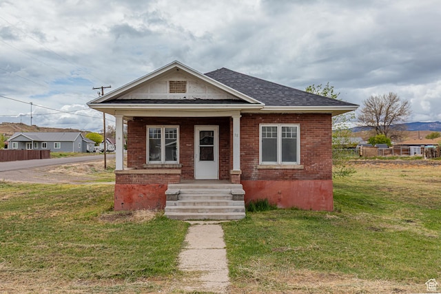 98 S Center St, Redmond, UT 84652 - view of front of home featuring a front yard, a shingled roof, and brick siding