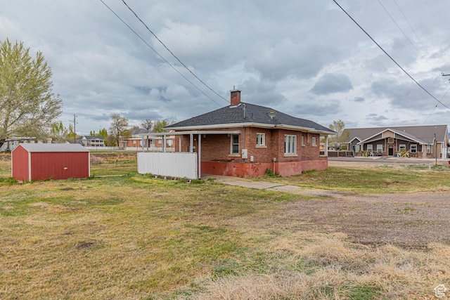 98 S Center St, Redmond, UT 84652 - rear view of property featuring a chimney, brick siding, a lawn, and an outdoor structure