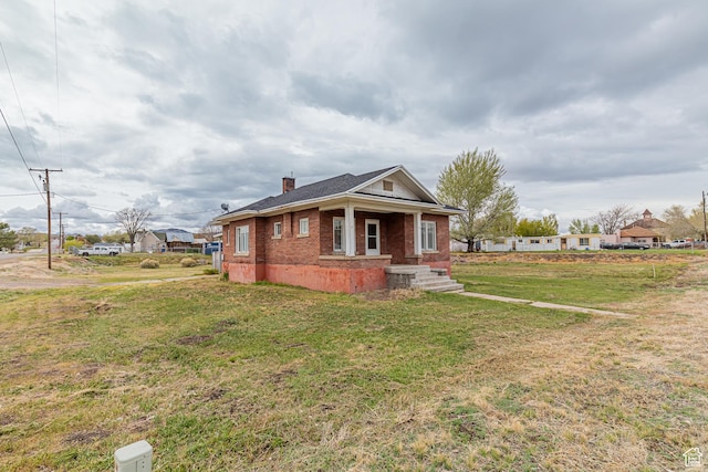 98 S Center St, Redmond, UT 84652 - view of front facade featuring a chimney, brick siding, a front yard, and a porch
