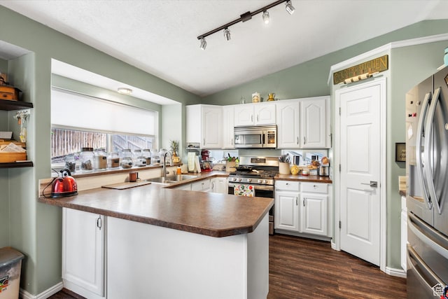 3347 N 1150 E, Layton, UT 84040 - kitchen with appliances with stainless steel finishes, a sink, dark countertops, white cabinetry, and a peninsula