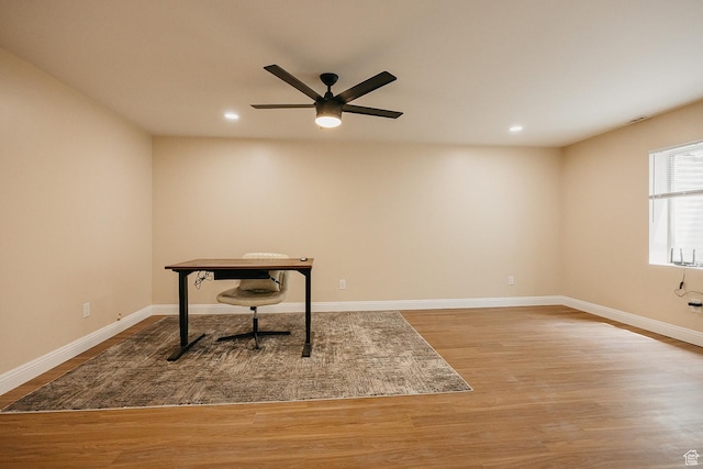 unfurnished office with wood finished floors, ceiling fan, recessed lighting, and baseboards