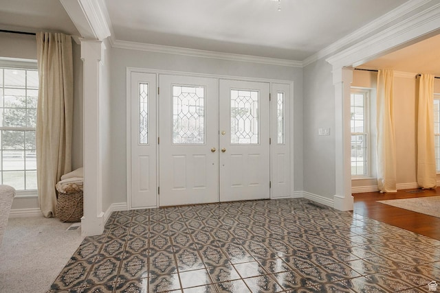 foyer featuring ornate columns, plenty of natural light, ornamental molding, and baseboards