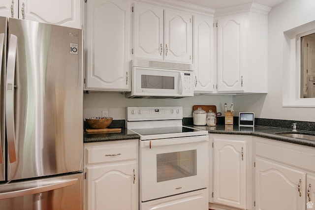 kitchen with white appliances, white cabinetry, and a sink