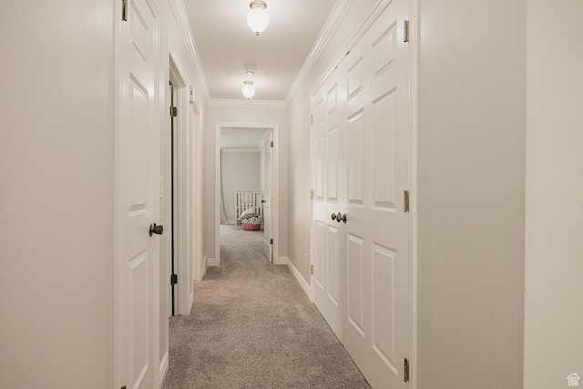 hallway with carpet flooring, ornamental molding, and baseboards