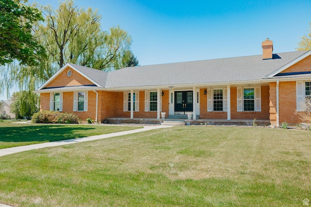 ranch-style house featuring brick siding, a chimney, a front lawn, a porch, and french doors