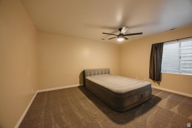 bedroom with baseboards, dark carpet, and a ceiling fan