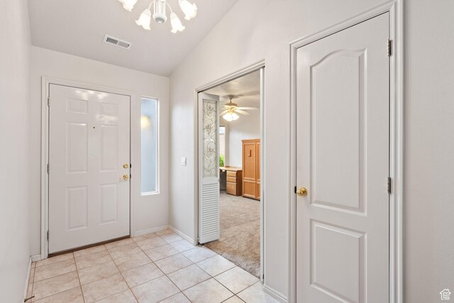 entrance foyer with a chandelier, light tile patterned floors, and baseboards