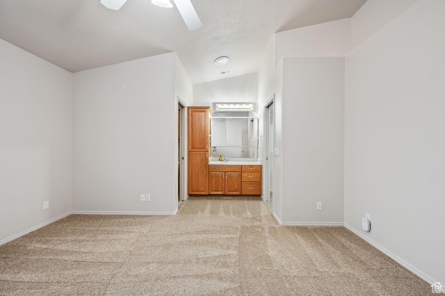 unfurnished bedroom featuring light colored carpet, baseboards, and ensuite bathroom