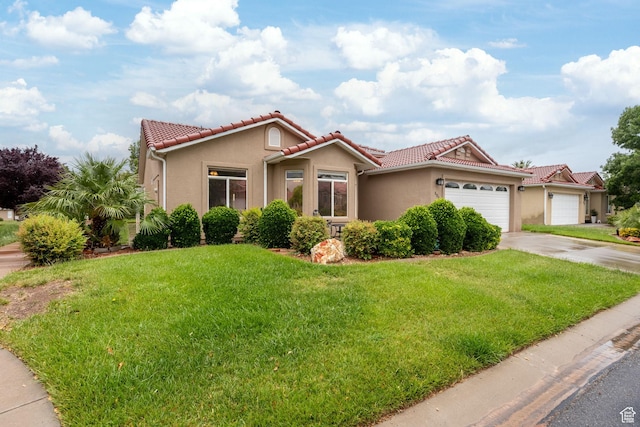 mediterranean / spanish-style home featuring stucco siding, an attached garage, a tile roof, and a front lawn