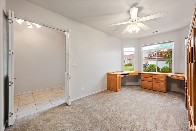 unfurnished office featuring light carpet, ceiling fan, and baseboards