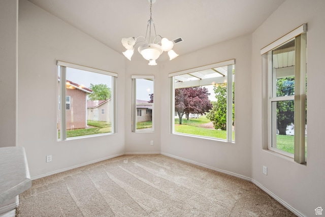 carpeted spare room featuring a chandelier, baseboards, and vaulted ceiling