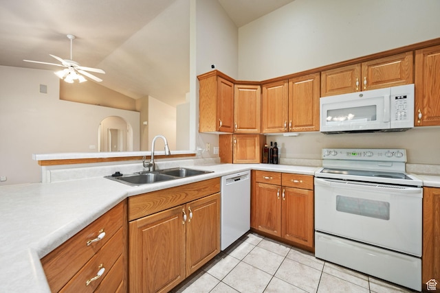 kitchen with white appliances, a sink, vaulted ceiling, light countertops, and light tile patterned floors