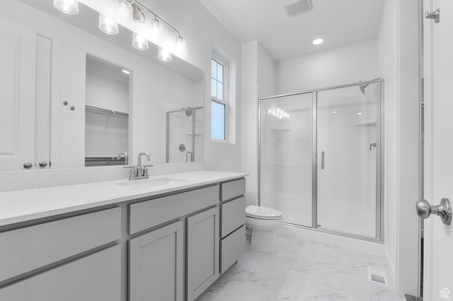 full bath with a stall shower, marble finish flooring, vanity, toilet, and a spacious closet