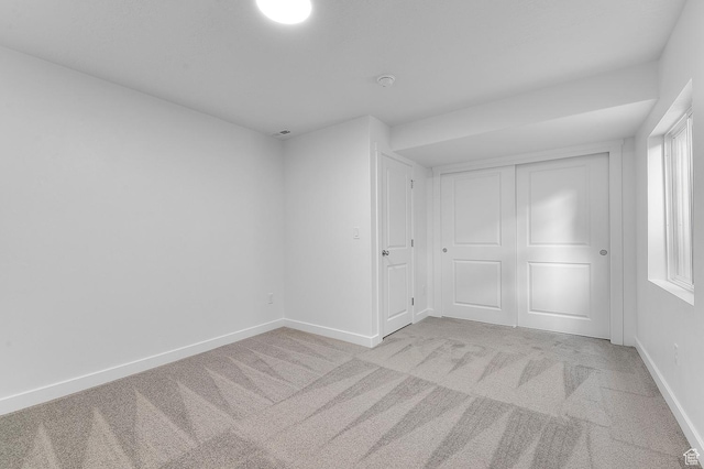 unfurnished bedroom featuring carpet floors, baseboards, and a closet
