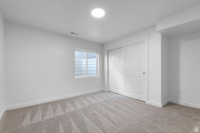 unfurnished bedroom featuring carpet floors, a closet, and baseboards