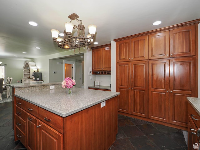 kitchen featuring a chandelier, recessed lighting, a center island, light countertops, and dark stone finish flooring
