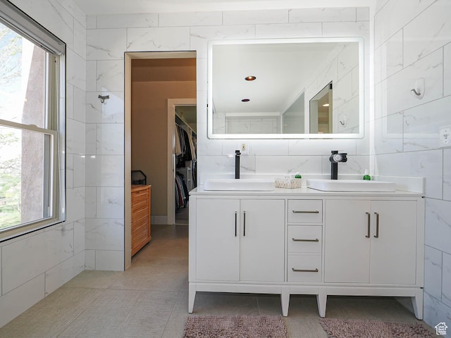 full bathroom featuring double vanity and a walk in closet