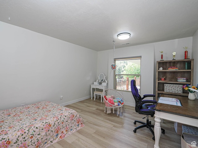 bedroom with wood finished floors, baseboards, and a desk