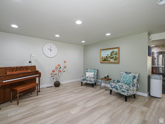 sitting room featuring light wood-type flooring, baseboards, and recessed lighting