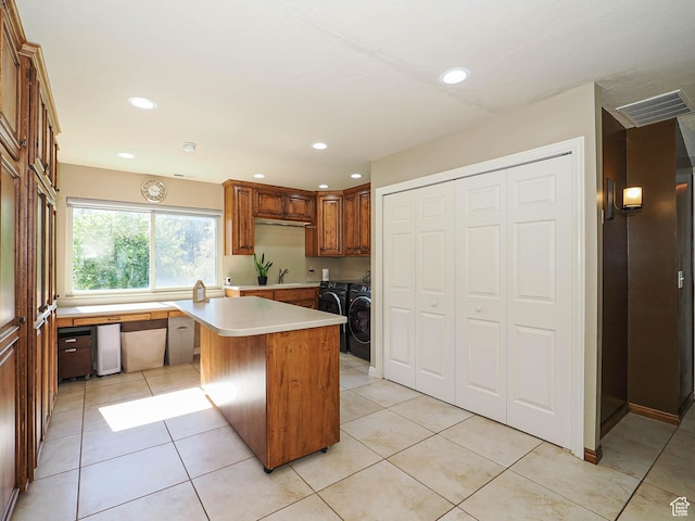 kitchen with independent washer and dryer, light countertops, a sink, light tile patterned floors, and recessed lighting