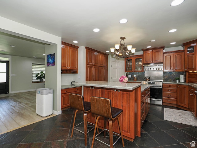 kitchen featuring stainless steel range with electric stovetop, a chandelier, glass insert cabinets, recessed lighting, and baseboards