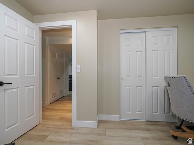 unfurnished office featuring baseboards and light wood-style flooring