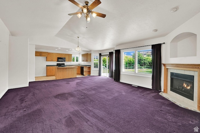 3267 S 1350 W, Perry, UT 84302 - unfurnished living room featuring carpet, a tiled fireplace, vaulted ceiling, a ceiling fan, and baseboards
