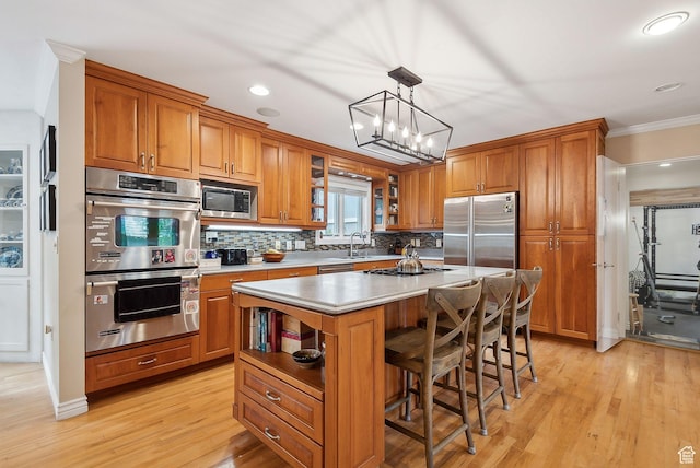 2625 E Kentucky Ave, Holladay, UT 84117 - kitchen featuring built in appliances, brown cabinets, tasteful backsplash, a center island, and crown molding
