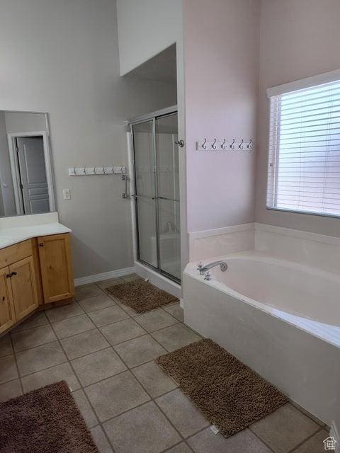 bathroom with tile patterned floors, vanity, a stall shower, and a bath