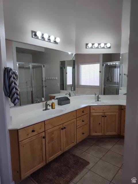 full bathroom featuring a shower stall, tile patterned flooring, and double vanity